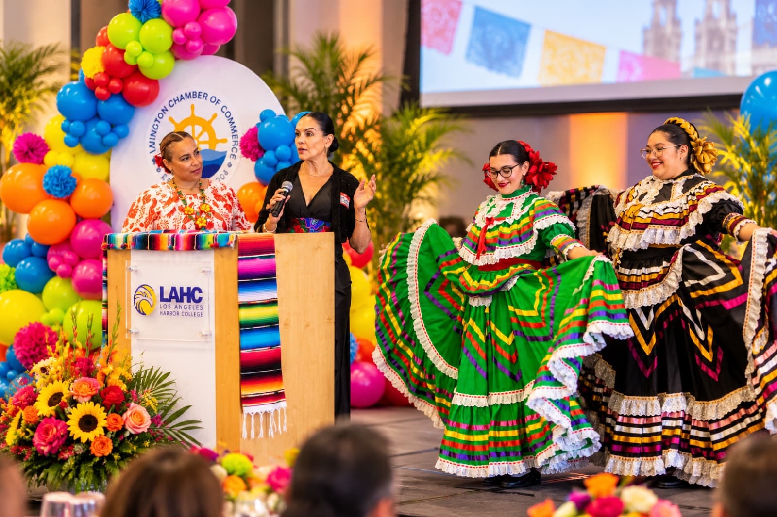Speakers and folklórico dancers on stage at the Wilmington Chamber of Commerce Cinco de Mayo luncheon, planned by ACCM Event Planning